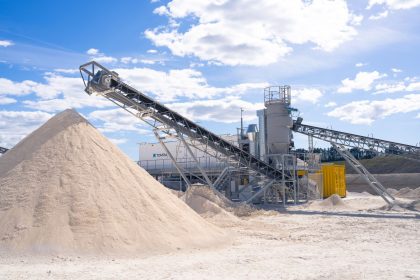 Planta industrial de processamento mineral com esteiras transportadoras ao ar livre.