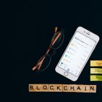 Smartphone exibe informações do mercado de criptomoedas sobre fundo escuro com elementos visuais associados à tecnologia blockchain.