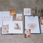 Materiais de branding, paletas de cores e documentos de planejamento estratégico dispostos sobre uma superfície de concreto