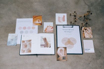 Materiais de branding, paletas de cores e documentos de planejamento estratégico dispostos sobre uma superfície de concreto