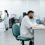 Pesquisadores analisam amostras e equipamentos em um laboratório moderno.