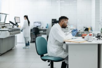 Pesquisadores analisam amostras e equipamentos em um laboratório moderno.