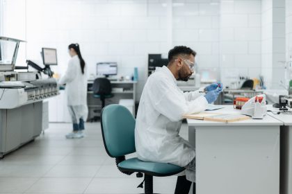 Pesquisadores analisam amostras e equipamentos em um laboratório moderno.